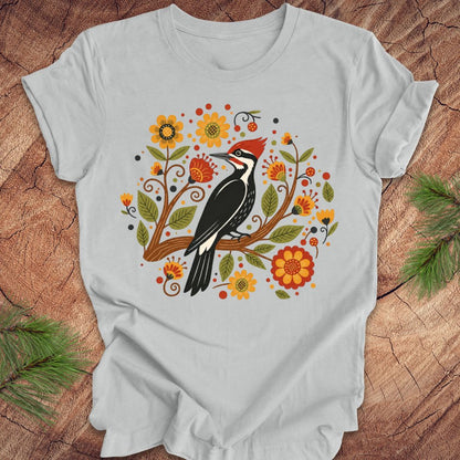 Gray t-shirt with a woodpecker design on a wooden surface