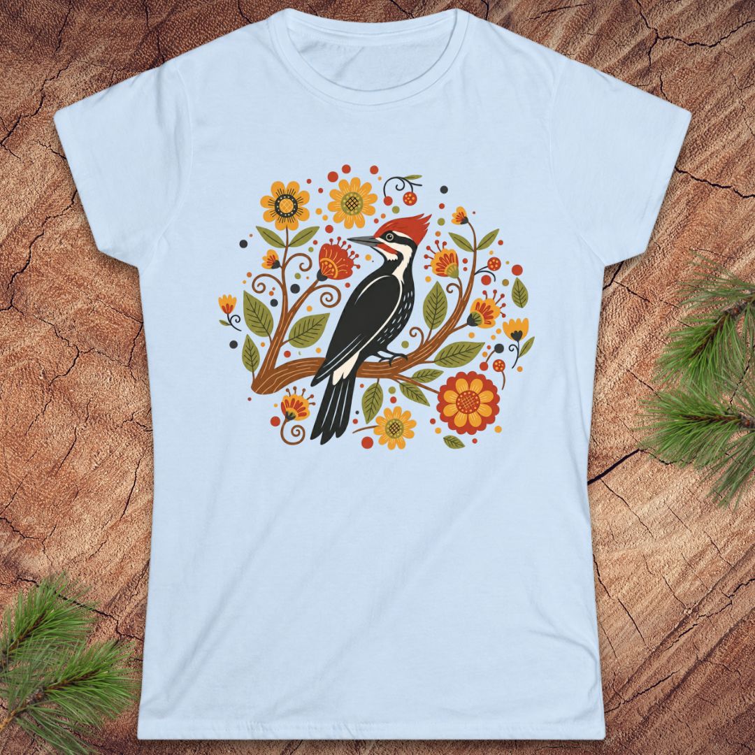 Light blue t-shirt with a woodpecker and floral design on a wood background.