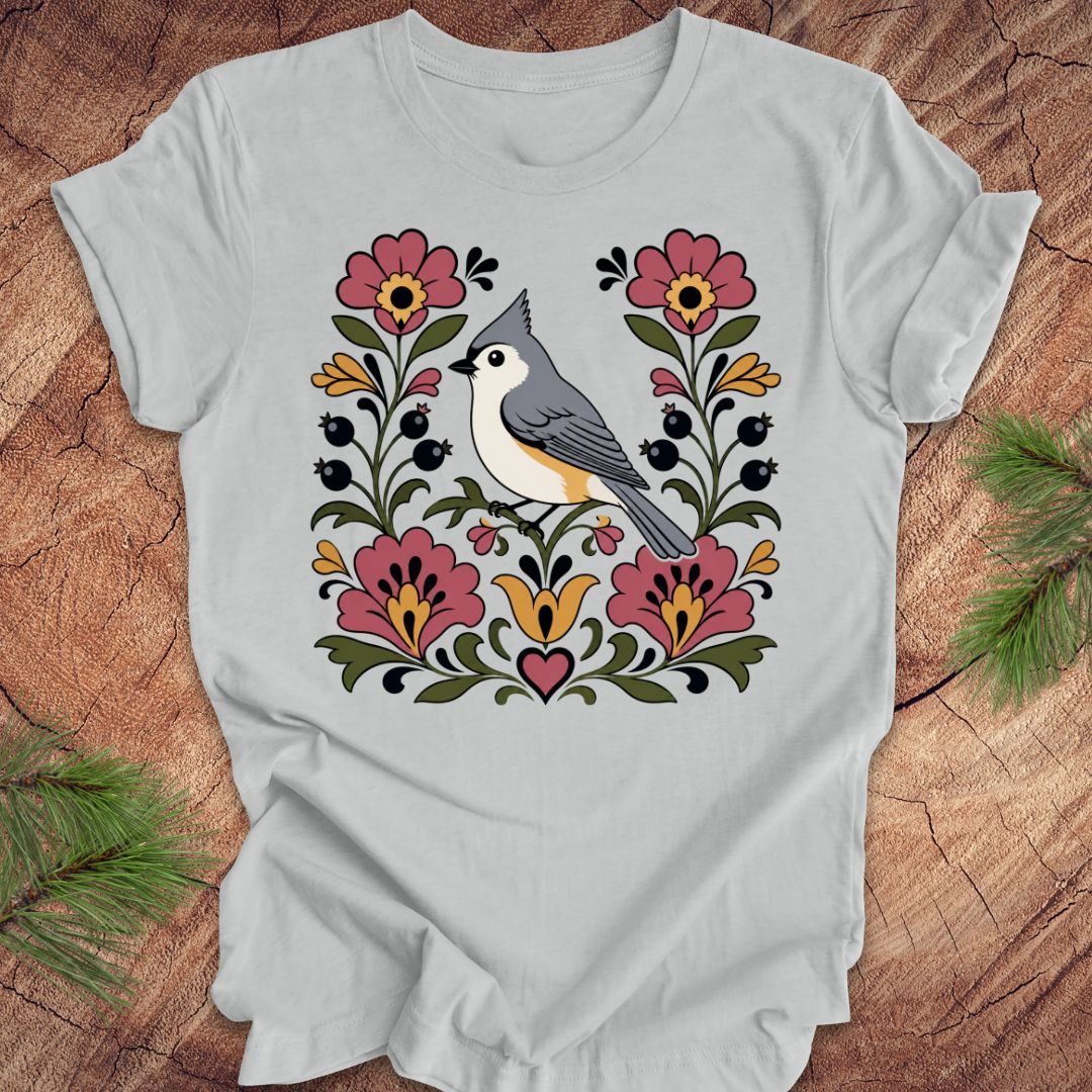 Gray t-shirt with a titmouse and floral design on a wooden surface