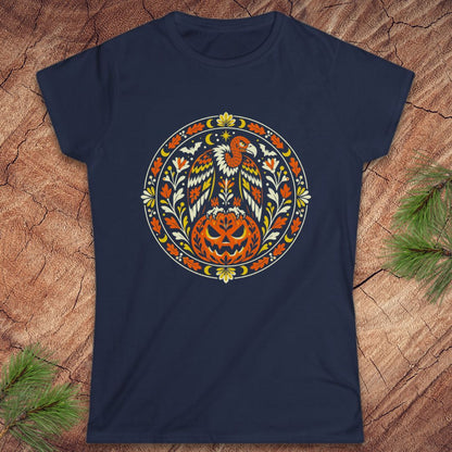 A navy blue short-sleeve t-shirt with a circular graphic of a bald eagle and a carved jack-o'-lantern pumpkin, displayed flat on a textured wood background with pine branches in the corners.