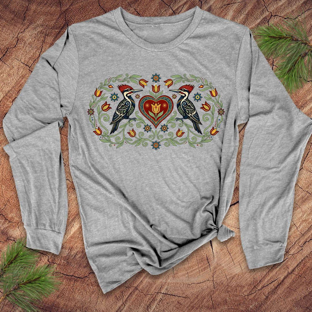 Gray long-sleeve shirt with nature-themed design on a wooden surface