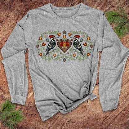 Gray long-sleeve shirt with nature-themed design on a wooden surface