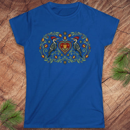 Blue t-shirt with a decorative design of two birds and a heart on a wooden surface.