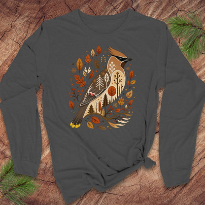 A dark gray long-sleeve t-shirt with a graphic of a bird surrounded by autumn leaves, styled flat on a rustic wood background with pine branches.