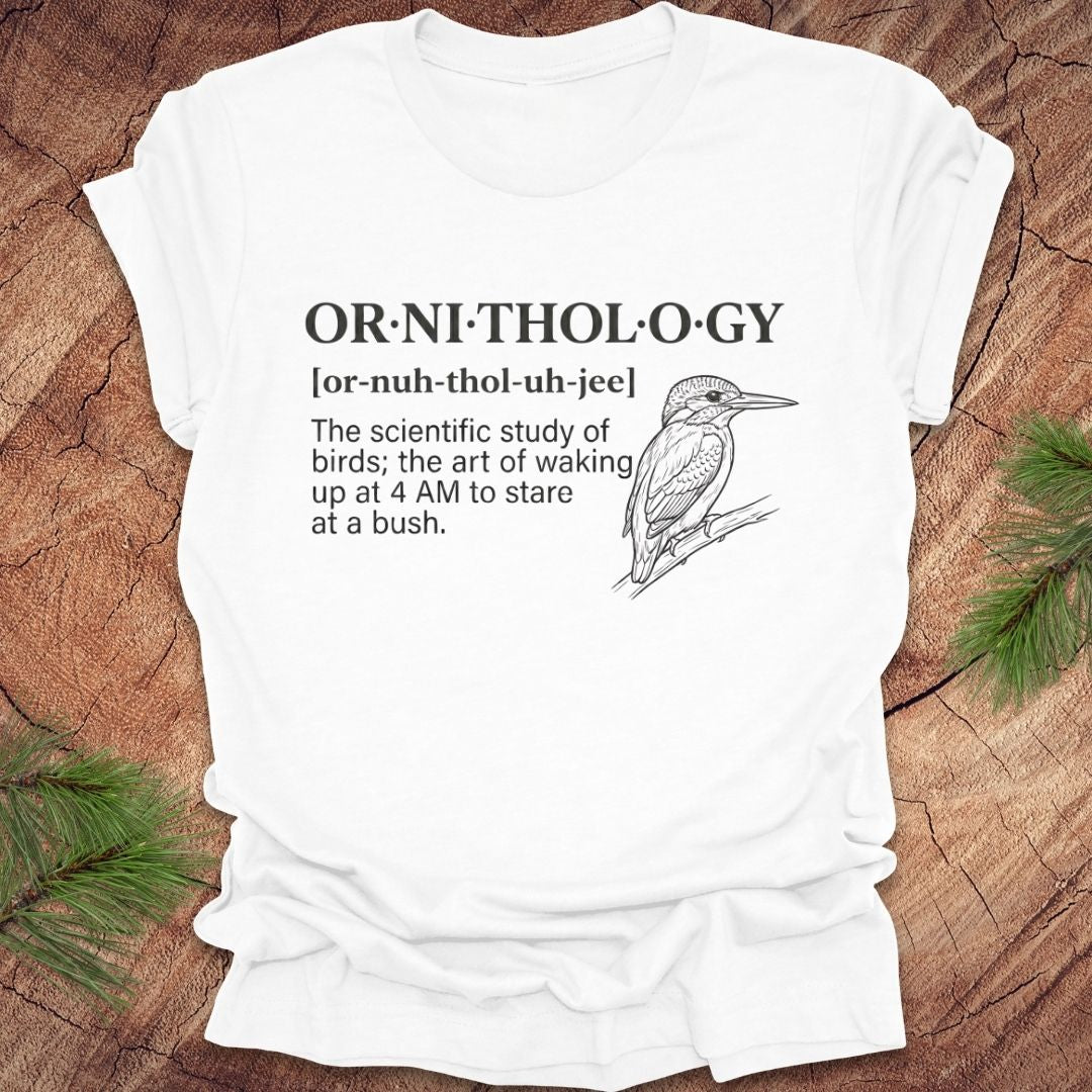 White t-shirt with a funny version of the definition of the word ornithology, with a picture of a bird, on a wood background.