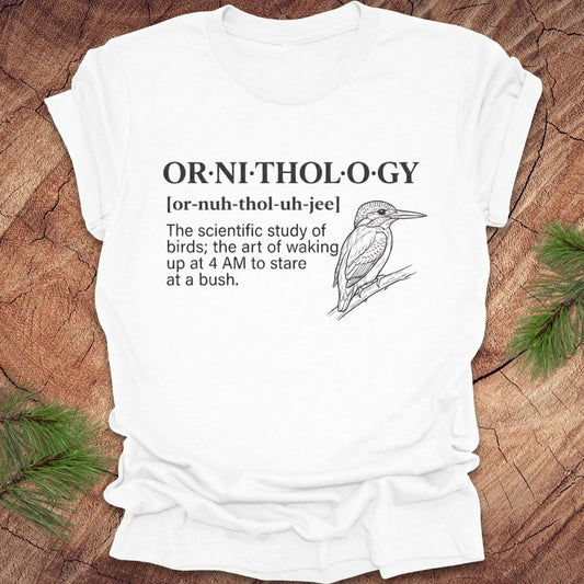 White t-shirt with a funny version of the definition of the word ornithology, with a picture of a bird, on a wood background.