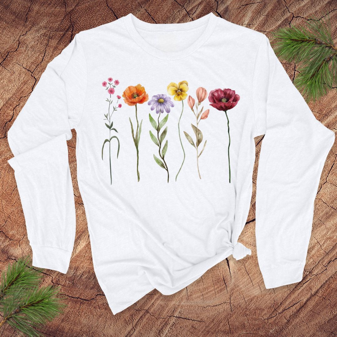 White long-sleeve shirt with floral design on a wooden surface