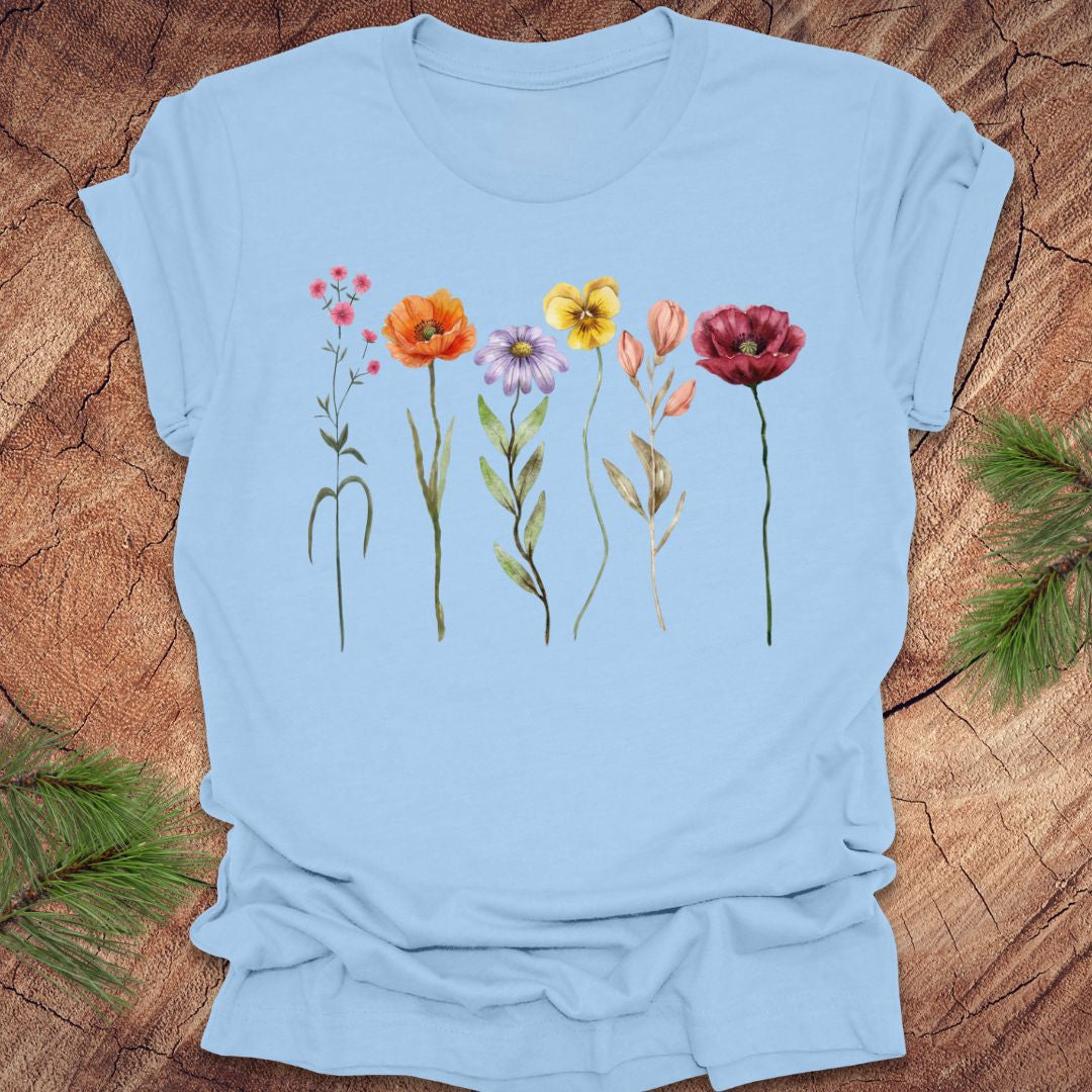 Light blue t-shirt with colorful floral design on a wooden surface