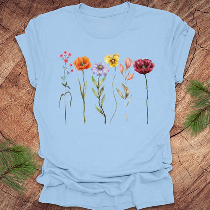 Light blue t-shirt with colorful floral design on a wooden surface
