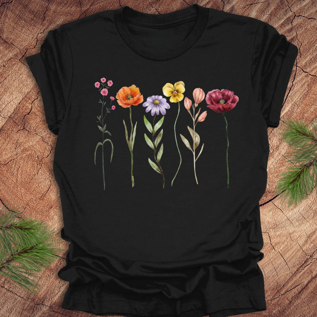 Black t-shirt with colorful floral design on a wooden surface