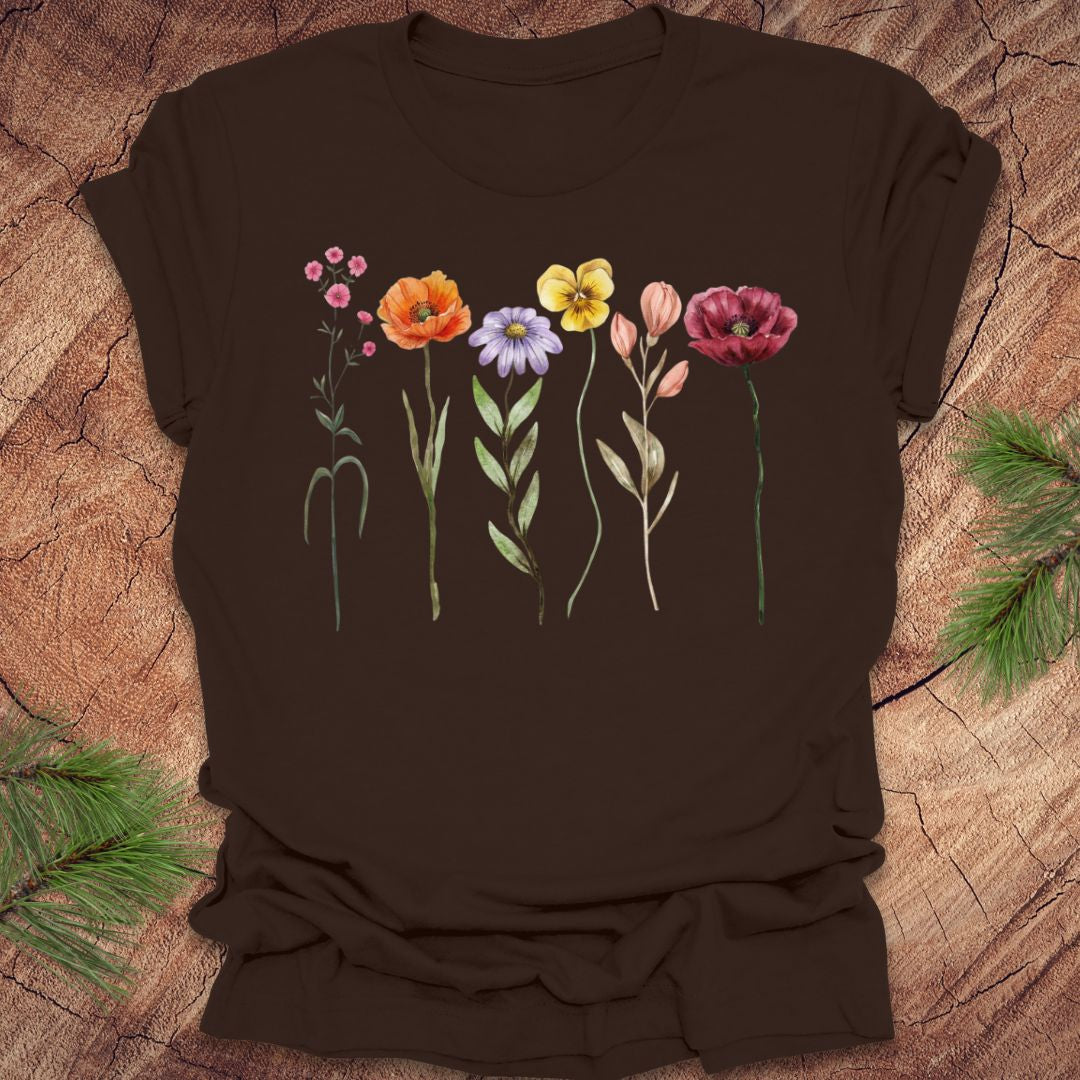 Brown t-shirt with colorful floral design on a wooden surface