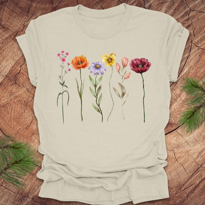 Beige t-shirt with colorful floral designs on a wooden surface