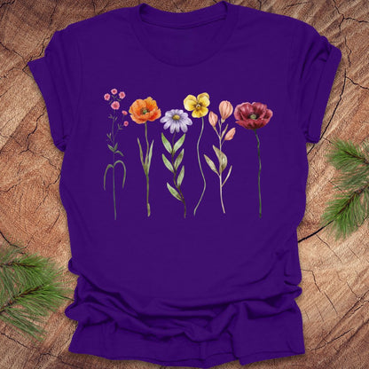 Purple t-shirt with colorful floral design on a wooden surface