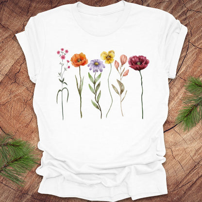 White t-shirt with colorful floral design on a wooden surface