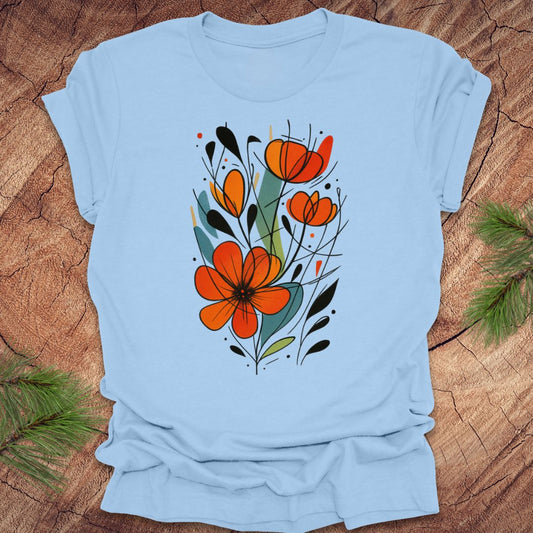 Light blue t-shirt with orange floral design on a wooden surface