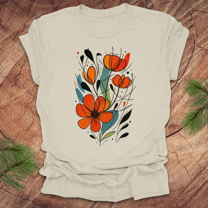 Beige t-shirt with orange floral design on a wooden surface