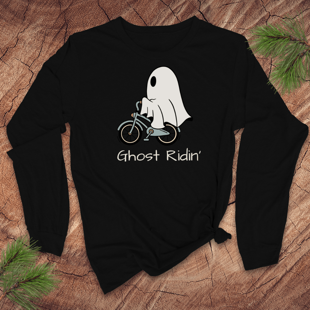 Black long sleeve tshirt with a ghost riding a bicycle graphic and 'Ghost Ridin'' text on a wooden surface.