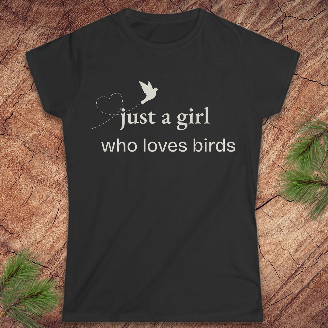Black t-shirt with a bird and text, 'just a girl who loves birds' on a wood background.