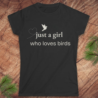 Black t-shirt with a bird and text, 'just a girl who loves birds' on a wood background.