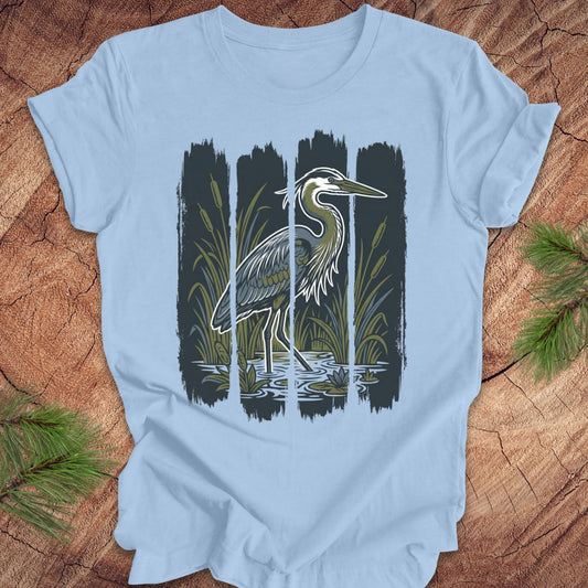 Light blue t-shirt with a heron design on a wooden surface