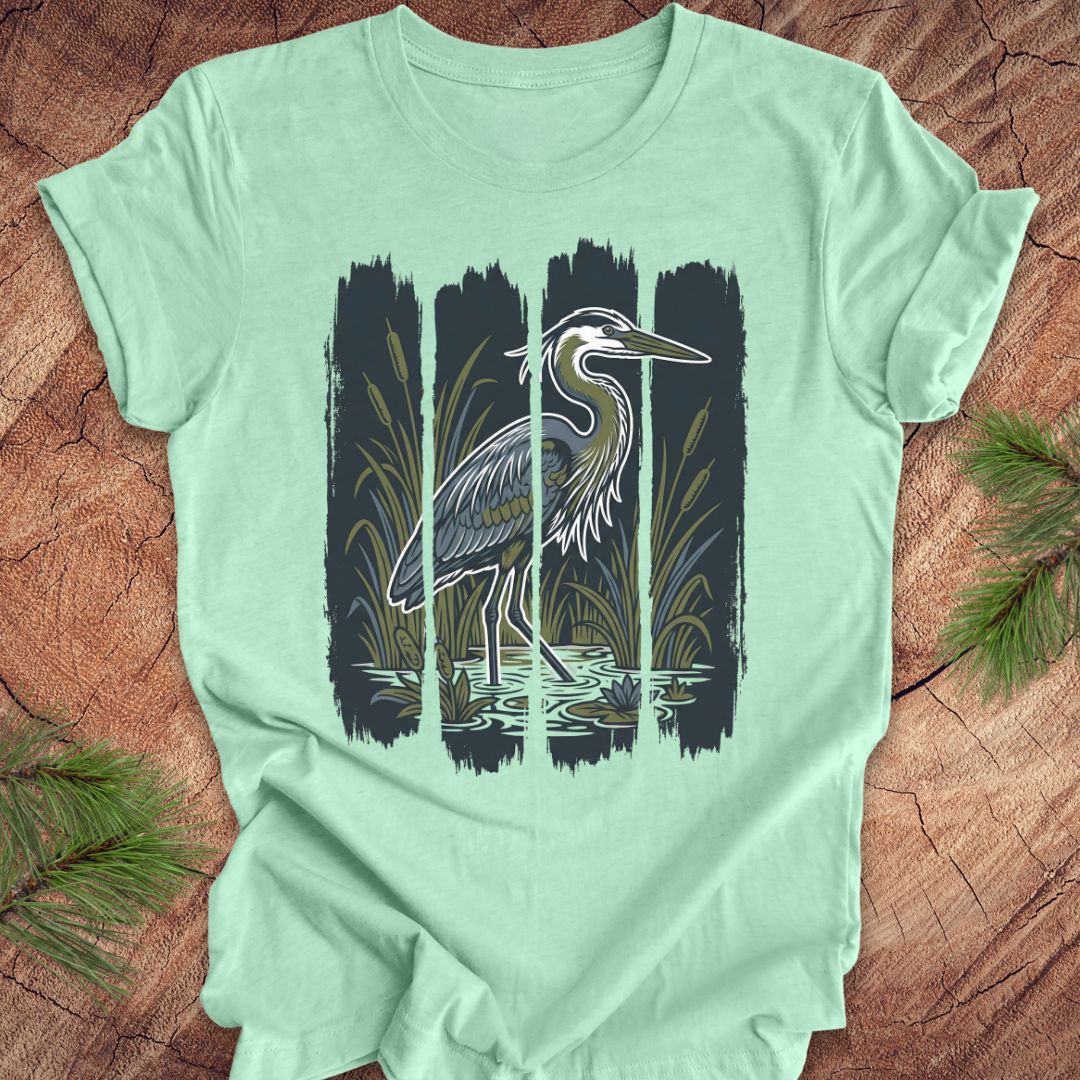 Mint green t-shirt with a heron design on a wooden surface