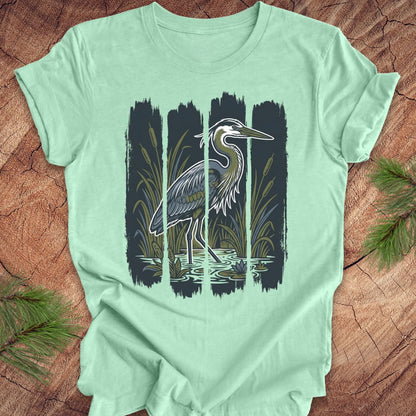 Mint green t-shirt with a heron design on a wooden surface