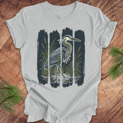 Gray t-shirt with a heron design on a wooden surface