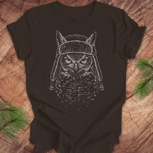 Brown t-shirt with an owl graphic wearing a helmet on a wooden surface.