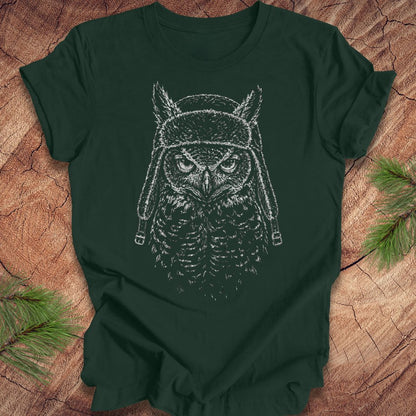 Green t-shirt with an owl design on a wooden surface