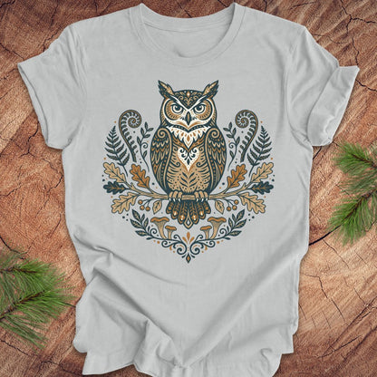 Gray t-shirt with an owl and woodland design on a wooden surface