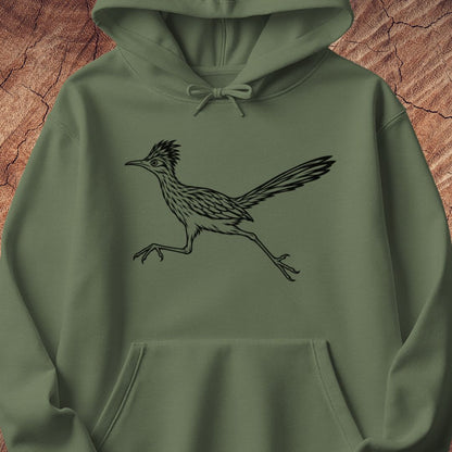 An olive green pullover hoodie featuring a black line art graphic of a running roadrunner bird on the chest, displayed against a textured brown wood background.
