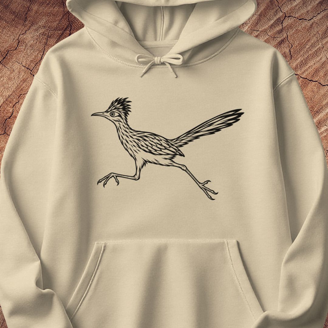 A cream-colored hoodie featuring a black line art illustration of a running roadrunner bird on the chest, displayed against a textured brown wood background.