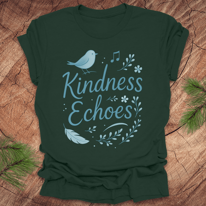 Green t-shirt with birds and flowers and text, 'Kindness Echoes' design on a wooden surface.