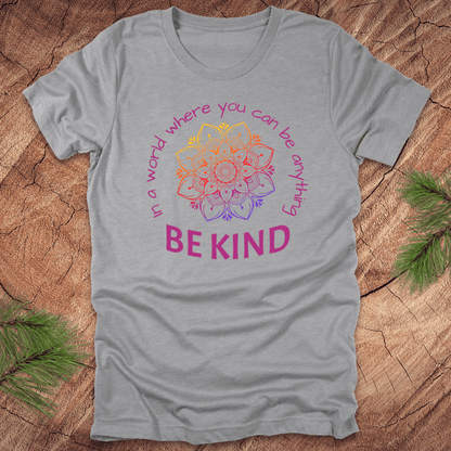 Gray t-shirt with a colorful mandala and 'Be Kind' text on a wooden surface