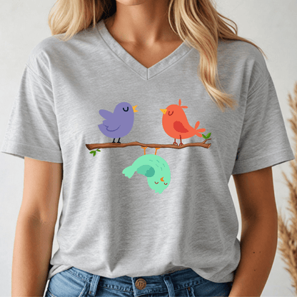 Person wearing a gray v-neck t-shirt with colorful birds on a branch design.