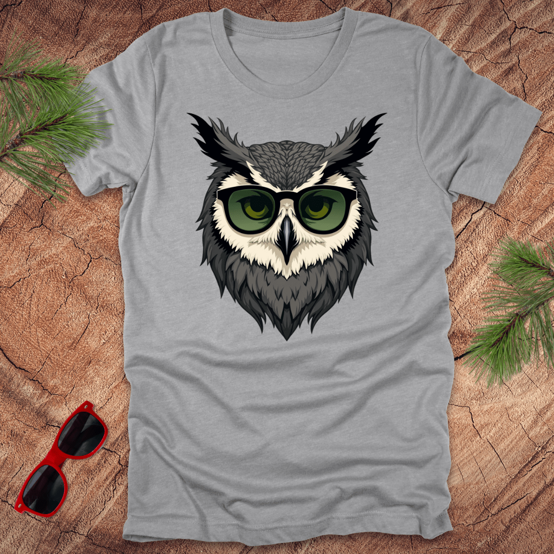 Grey tshirt with a graphic of an owl head with sunglasses on. it is on a wood background.