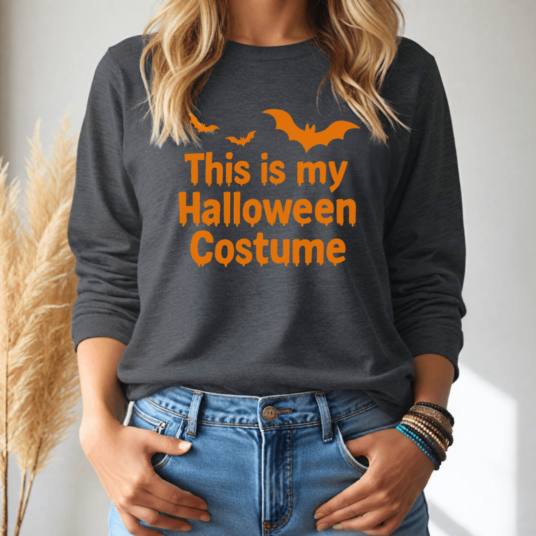 Person wearing a dark gray long sleeve tshirt with 'This is my Halloween Costume' text and orange bats on a plain background.