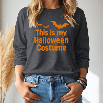 Person wearing a dark gray long sleeve tshirt with 'This is my Halloween Costume' text and orange bats on a plain background.