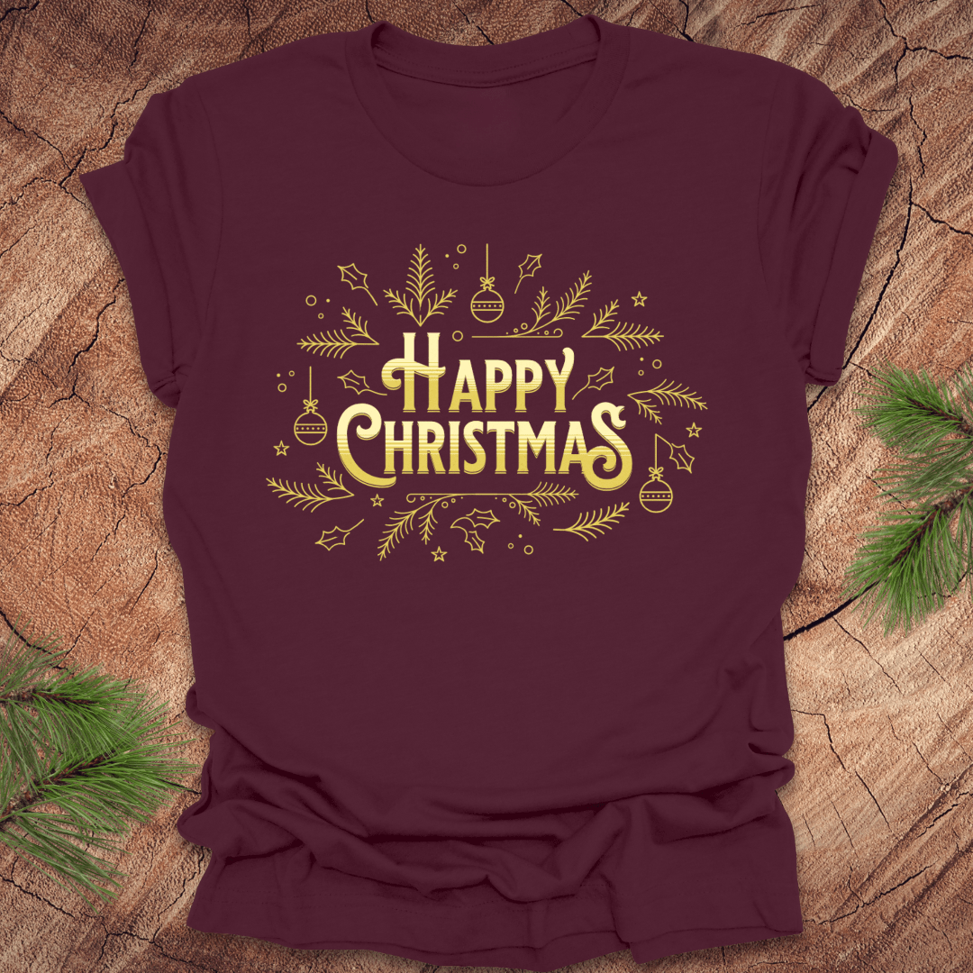 Maroon t-shirt with 'Happy Christmas' text and pine graphics on a wooden surface with pine branches.