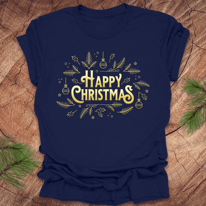 Navy t-shirt with 'Happy Christmas' text and pine graphics on a wooden surface with pine branches.