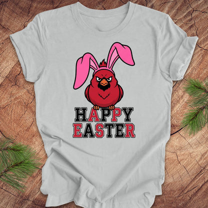 Gray t-shirt with a cardinal wearing bunny ears and 'Happy Easter' text on a wooden surface.