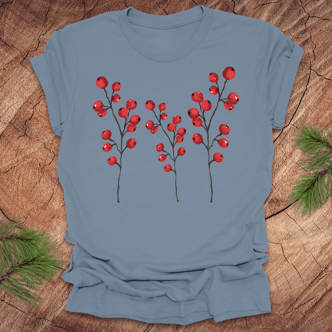 Steel blue t-shirt with three tall holly berry branches on a wood background with pine branches.