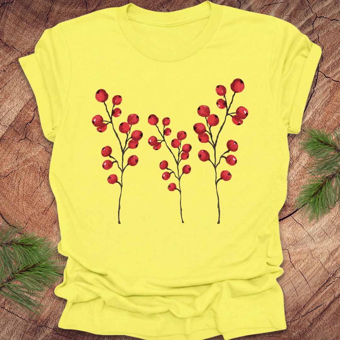 Yellow t-shirt with red berry design on a wooden surface