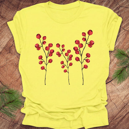Yellow t-shirt with red berry design on a wooden surface