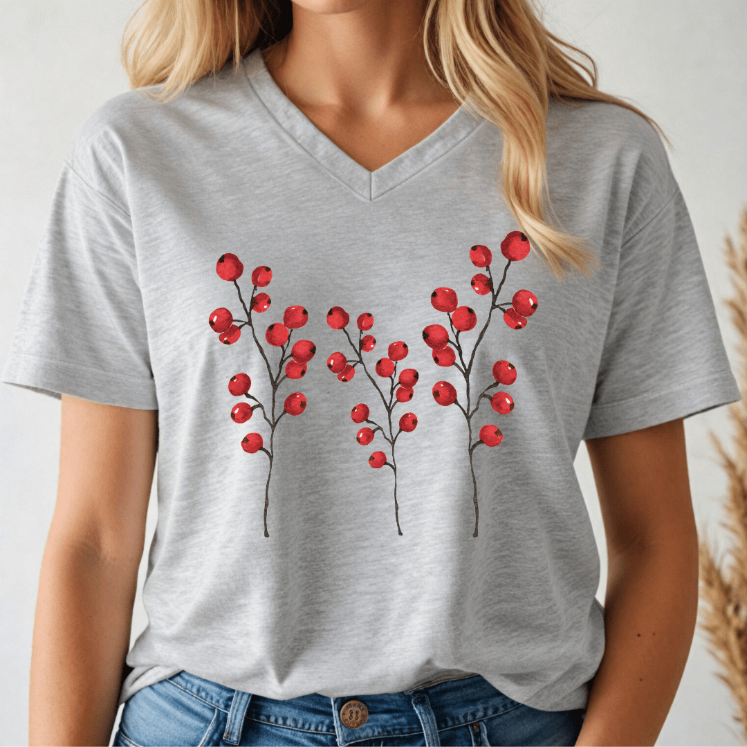 Person wearing a grey v-neck t-shirt with 3 holly branches with berries on a plain white background.