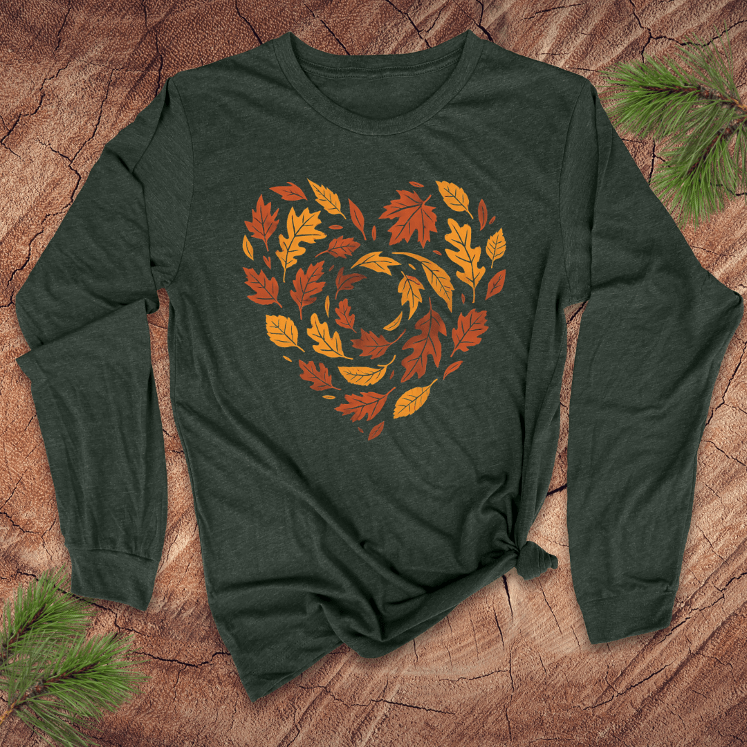 Green long sleeve tshirt with autumn leaf design in the shape of a heart on a wooden surface
