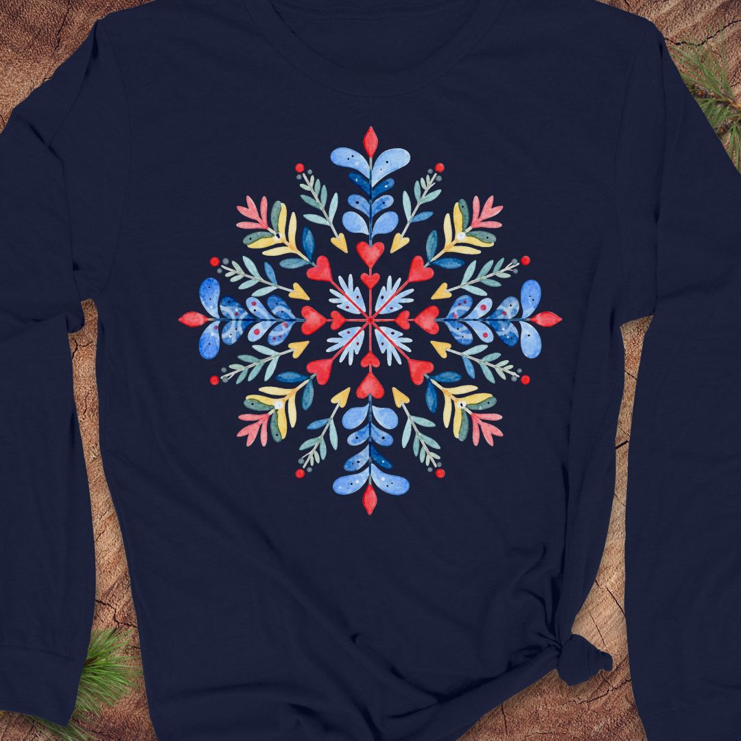 A navy blue long-sleeve t-shirt with a colorful, symmetrical floral snowflake graphic printed on the chest, laid flat on a rustic wood background.