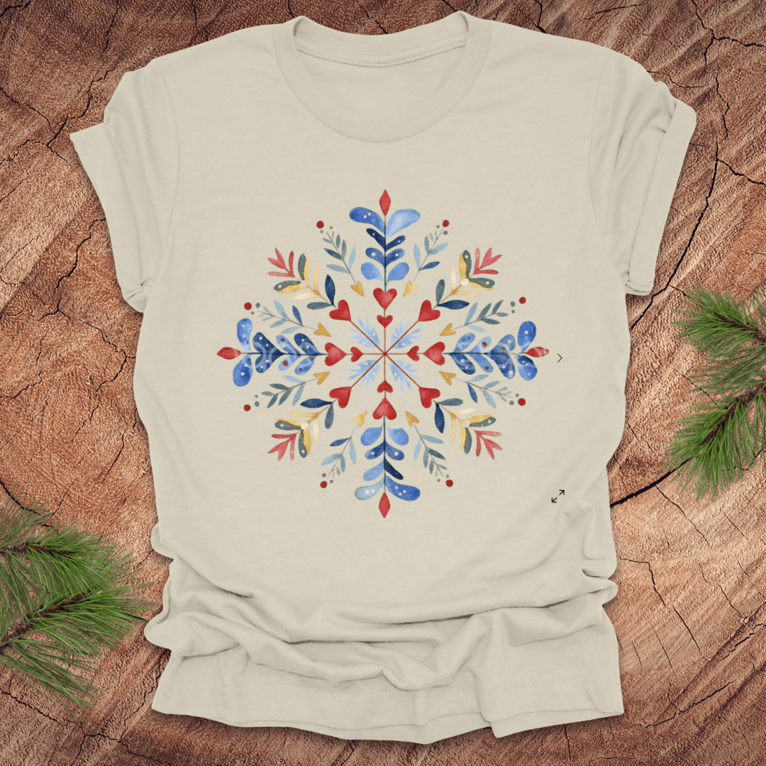 Beige t-shirt with a colorful snowflake floral design on a wooden surface