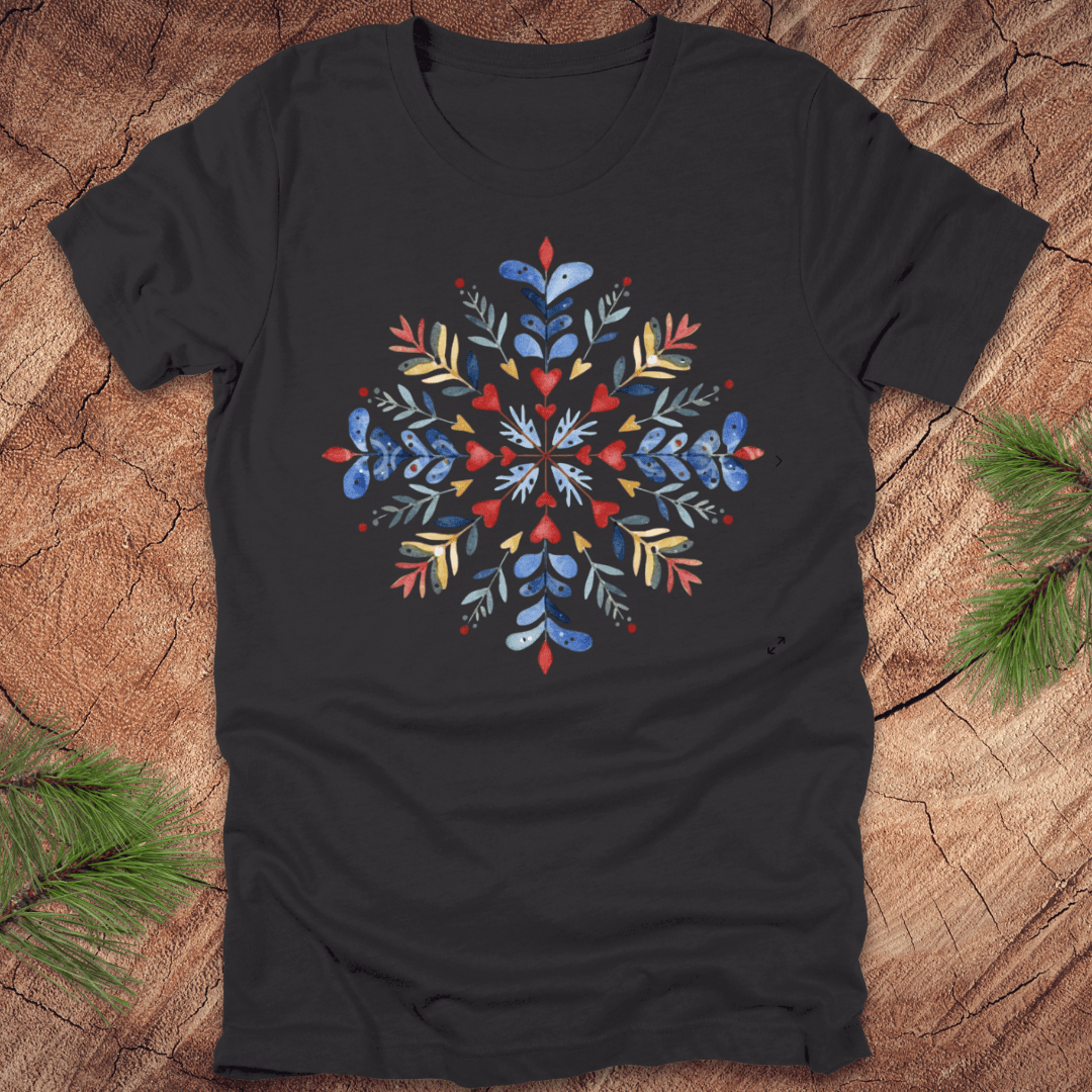 Dark grey t-shirt with a colorful snowflake floral design on a wooden surface