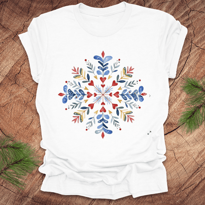 White t-shirt with a colorful snowflake floral design on a wooden surface